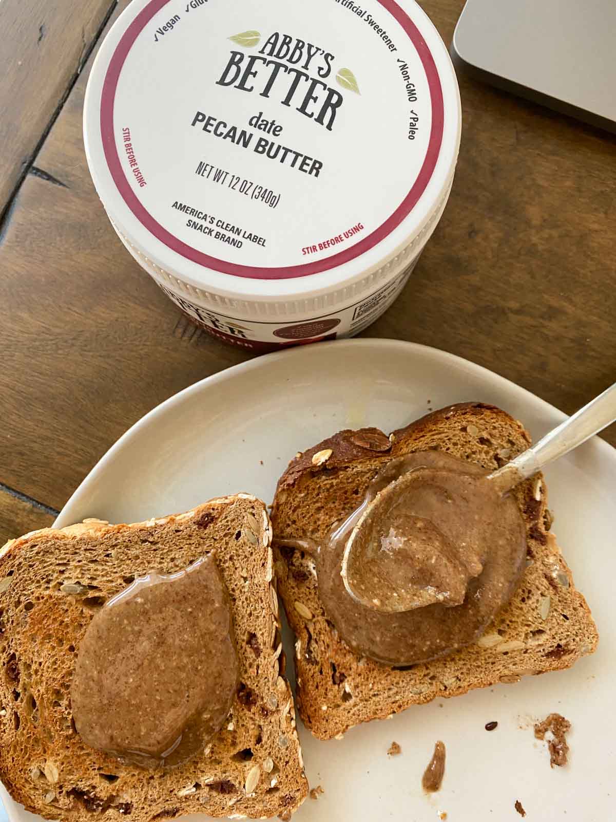 date pecan butter being spread on toast on white plate