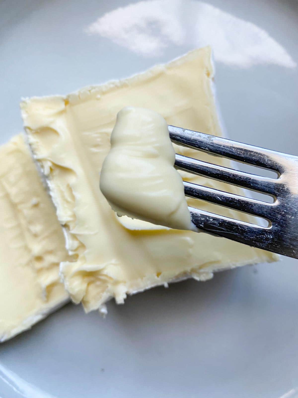 Fromage pavé cheese block from Trader Joe's cut in half with a bite on a fork