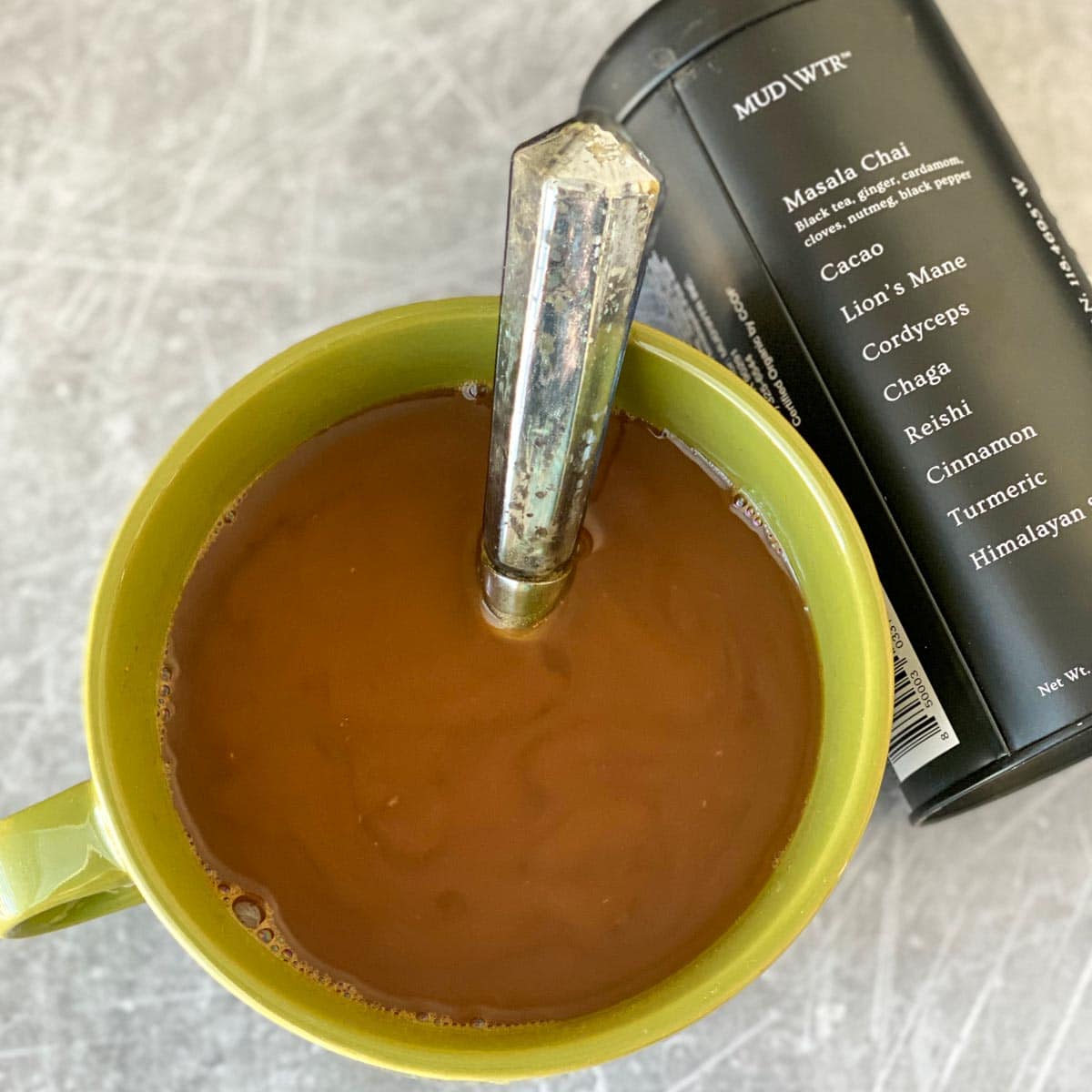 mud water in green mug next to labeled container