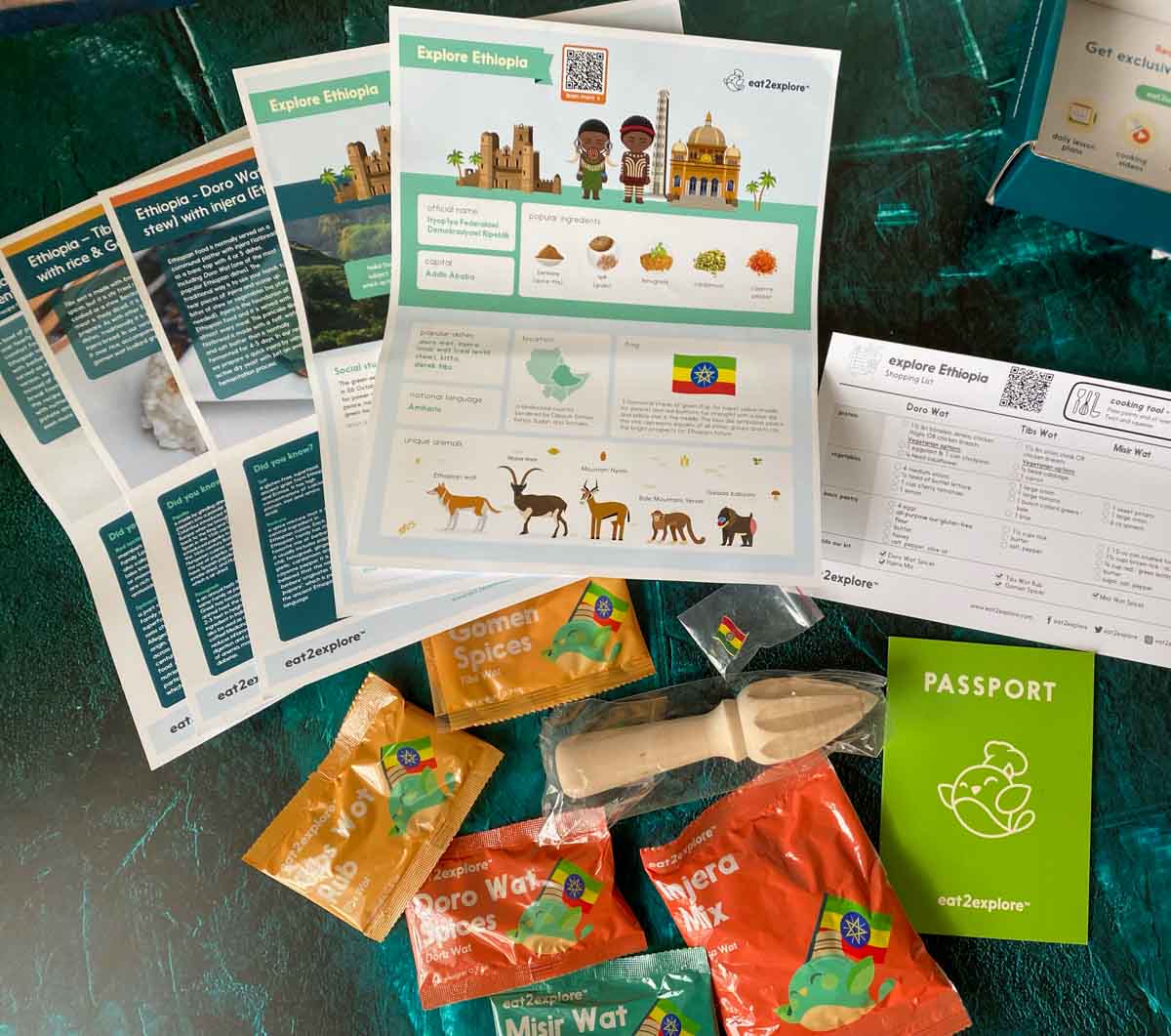 box contents from eat2explore Ethiopia kit - recipes cards, fact sheets and spices laid out on table