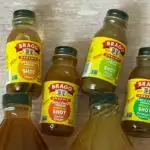 Bragg apple cider vinegar - 4 mini shot bottles laying above 2 large bottles