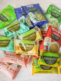 More than a dozen packages of Miracle Noodles in different varieties on table
