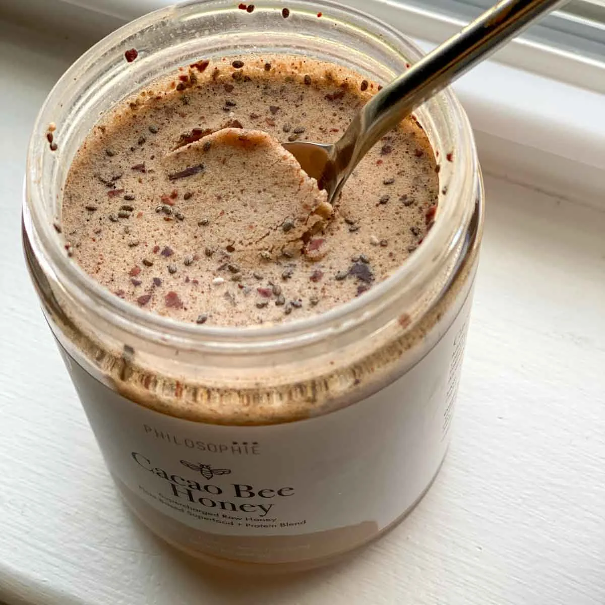 Philosophie's cacao bee honey with a spoon inside