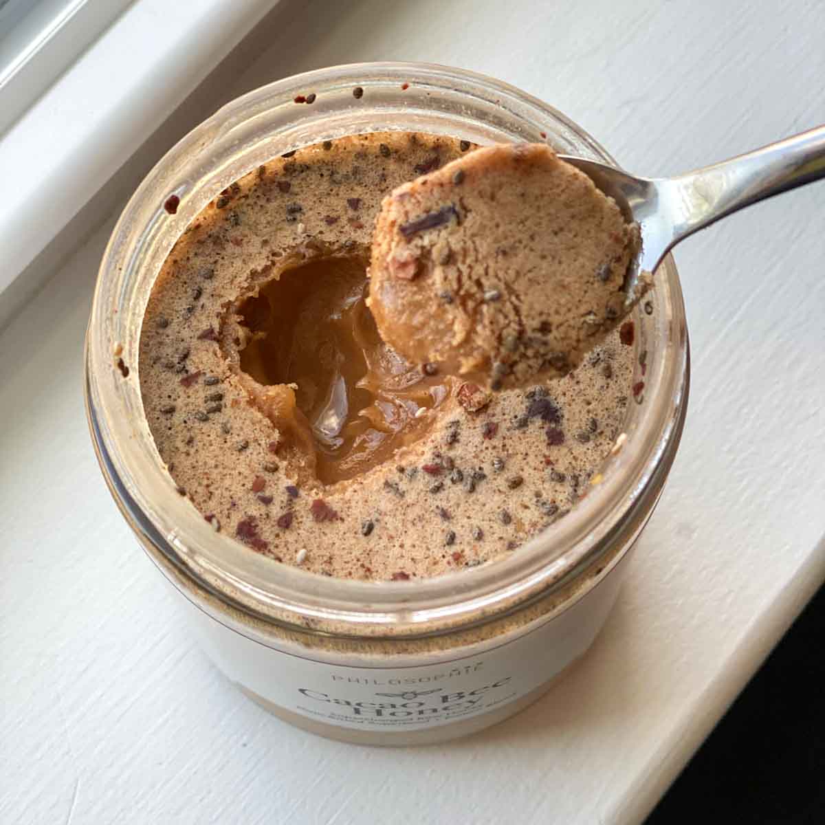 a spoonful of cacao bee honey raised out of jar