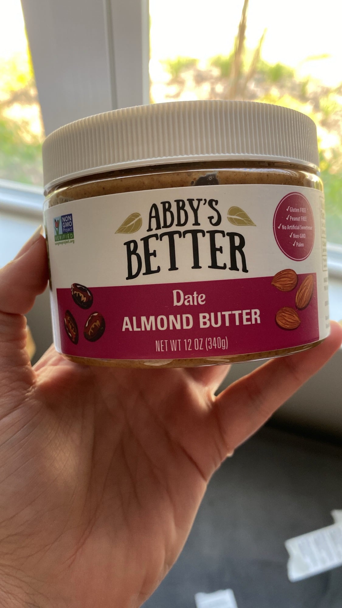 abby's better date almond butter jar held in hand