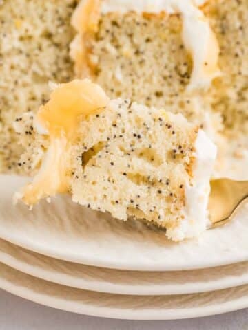 a closeup of a bite of lemon poppyseed cake on a fork.